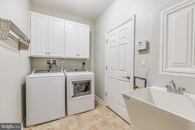 clothes washing area with sink, cabinets, and washing machine and clothes dryer