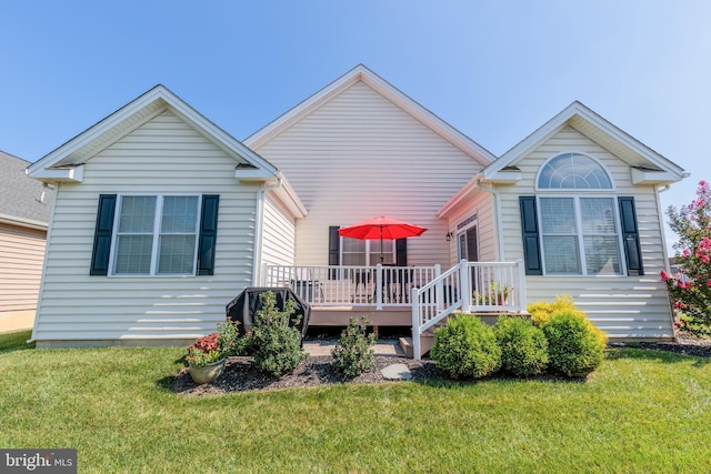 rear view of house with a deck and a lawn