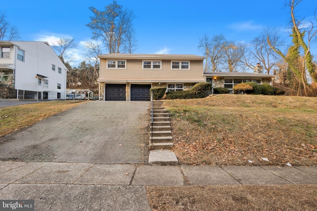 split level home with a garage and a front lawn