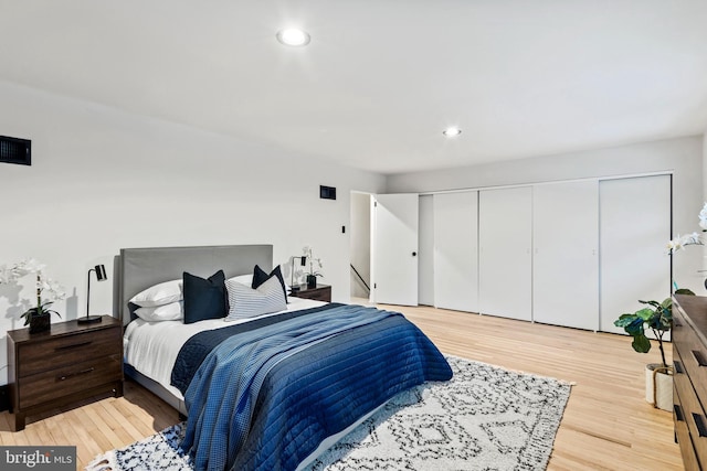 bedroom with light wood-type flooring and a closet