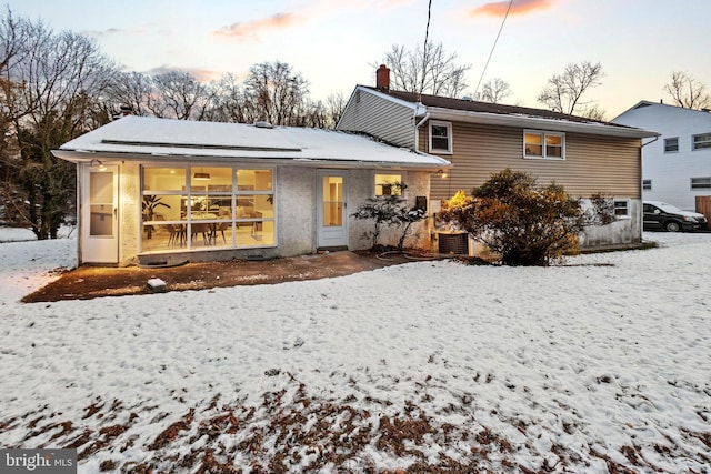 snow covered property featuring central AC unit