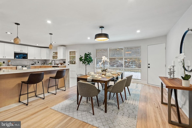 dining space featuring sink and light hardwood / wood-style floors