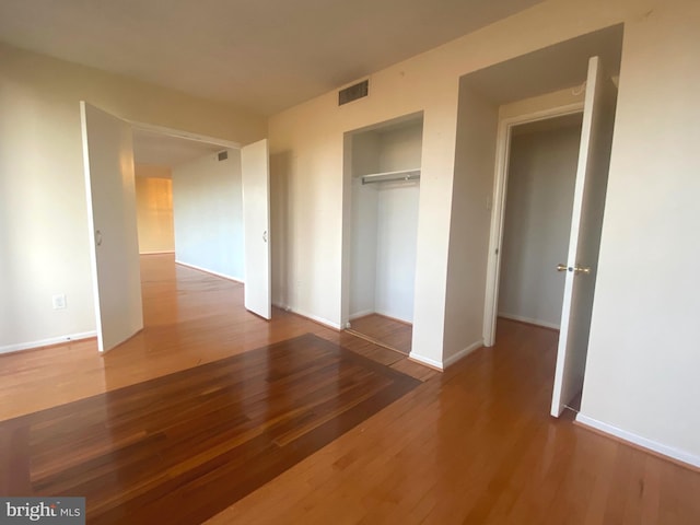 unfurnished bedroom with hardwood / wood-style flooring and a closet