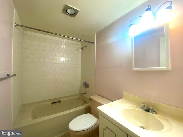 full bathroom featuring tiled shower / bath combo, toilet, and vanity