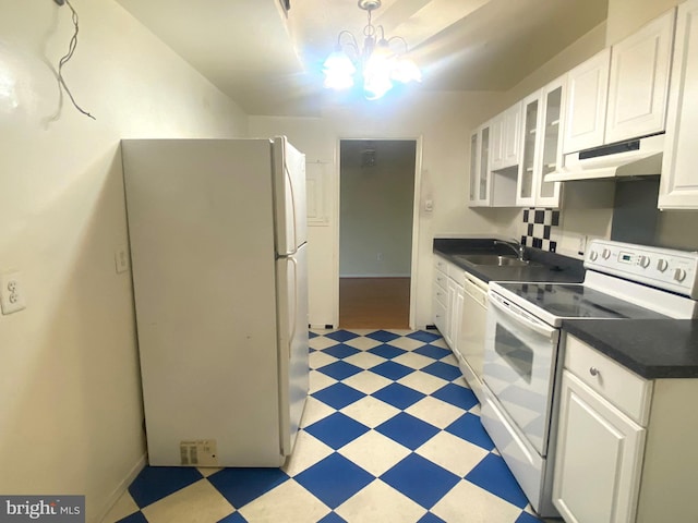 kitchen featuring pendant lighting, white appliances, white cabinets, sink, and a chandelier