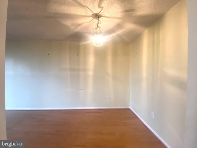 spare room with dark hardwood / wood-style floors and a textured ceiling