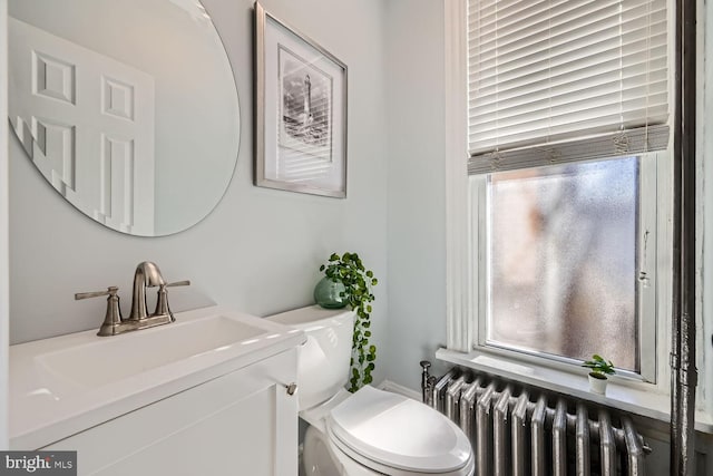 bathroom featuring radiator heating unit, vanity, and toilet