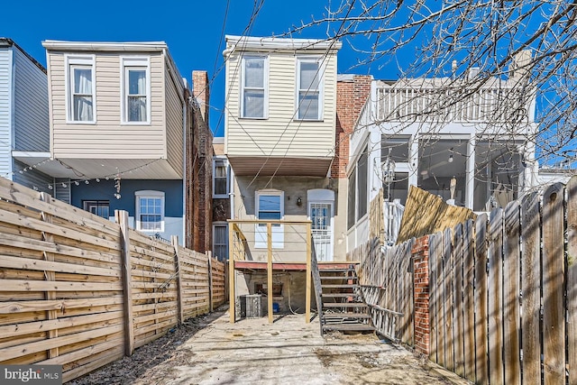 rear view of property featuring a fenced backyard