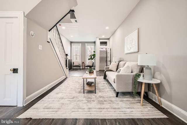 living area with stairs, recessed lighting, dark wood finished floors, and baseboards