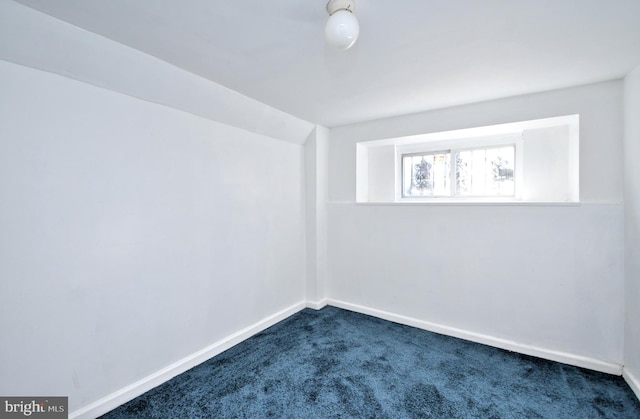 carpeted spare room with lofted ceiling