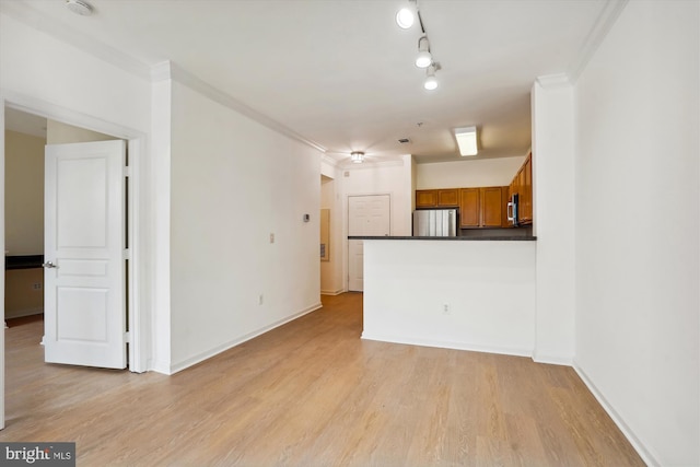 unfurnished living room with ornamental molding and light hardwood / wood-style flooring