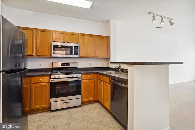 kitchen with kitchen peninsula, light tile patterned floors, stainless steel appliances, and sink