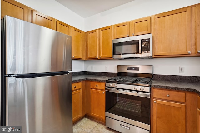 kitchen featuring light tile patterned floors and stainless steel appliances