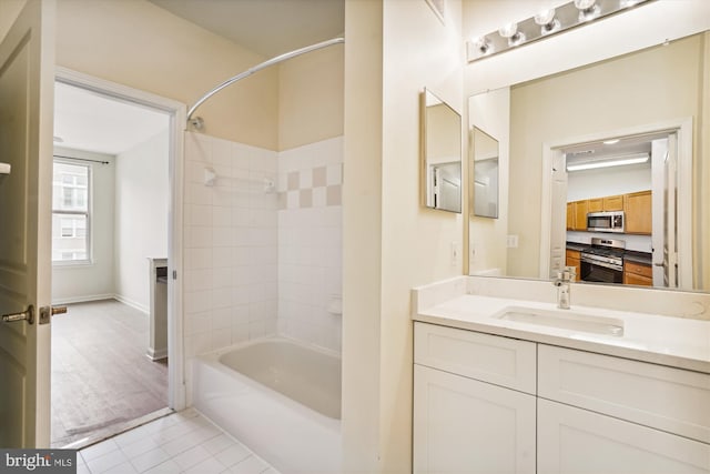 bathroom with tile patterned floors, tiled shower / bath combo, and vanity