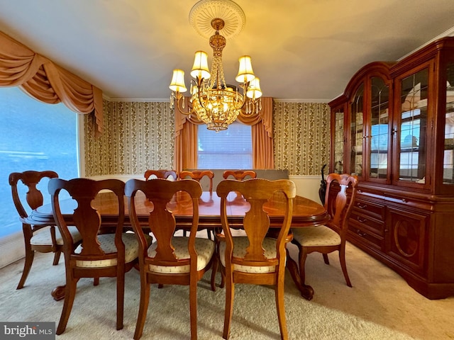 dining room with an inviting chandelier, crown molding, and light carpet