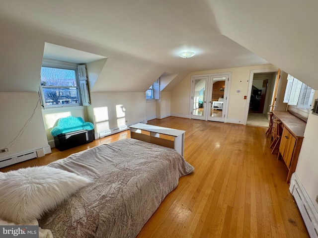 bedroom with a baseboard radiator, vaulted ceiling, and light hardwood / wood-style flooring