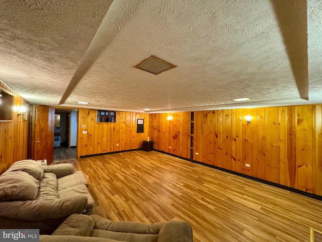 interior space featuring wooden walls, hardwood / wood-style floors, and a textured ceiling