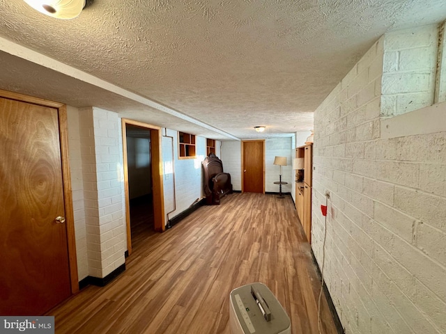 hall with hardwood / wood-style flooring and a textured ceiling