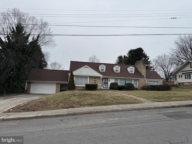 cape cod home featuring a garage and a front lawn