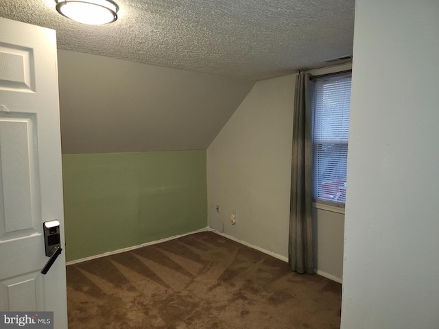 bonus room with dark carpet, a textured ceiling, and vaulted ceiling