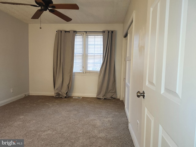 carpeted empty room featuring a textured ceiling and ceiling fan