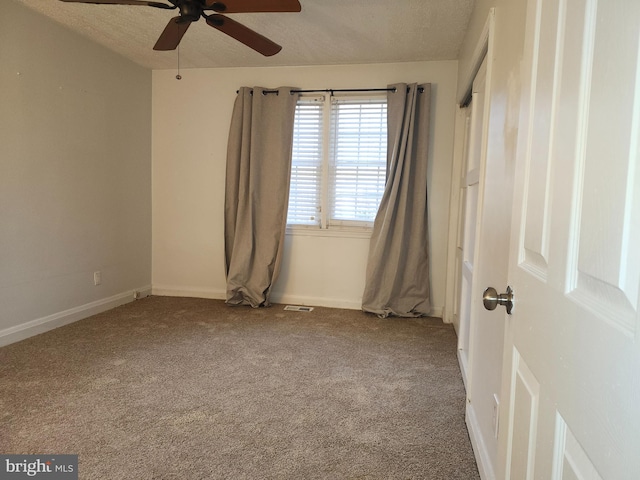 carpeted spare room with a textured ceiling and ceiling fan