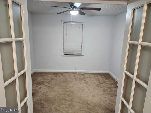 empty room featuring carpet flooring, a textured ceiling, and ceiling fan