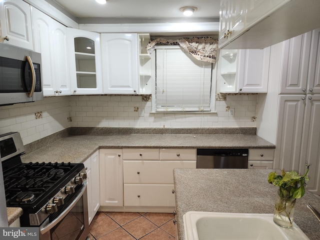 kitchen featuring white cabinets, stainless steel appliances, and light tile patterned floors