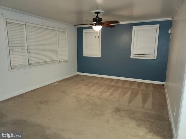 empty room with carpet flooring, ceiling fan, and ornamental molding