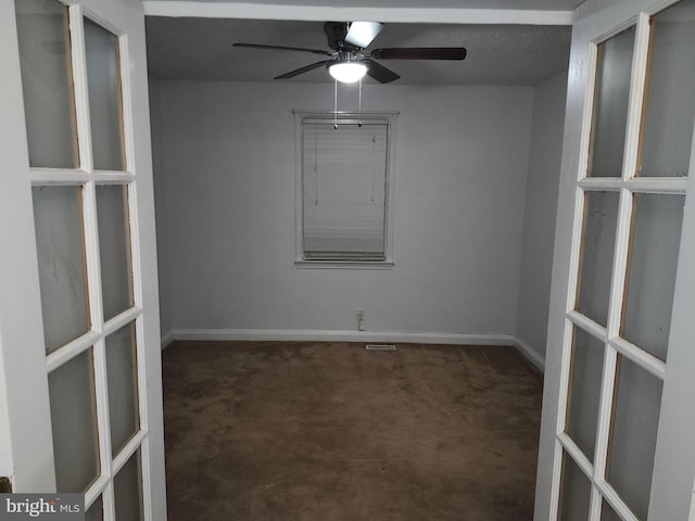 empty room featuring dark colored carpet, french doors, and ceiling fan