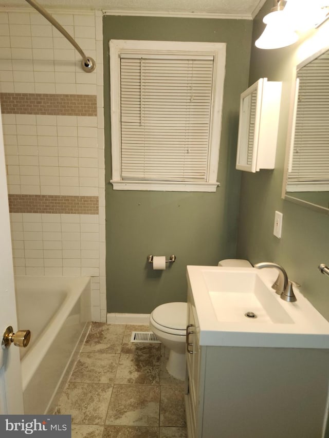 full bathroom with vanity, toilet, crown molding, and tiled shower / bath combo