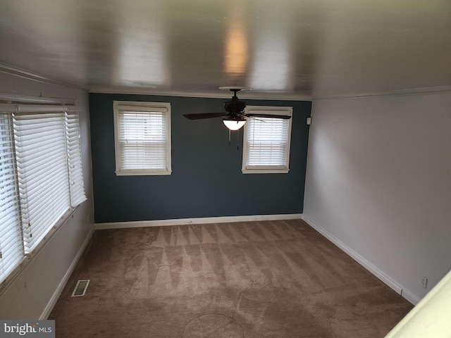 empty room with crown molding, plenty of natural light, and carpet