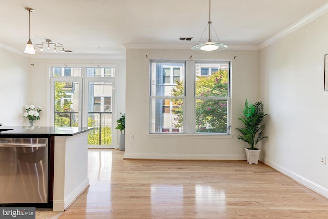 unfurnished dining area featuring ornamental molding and light hardwood / wood-style flooring