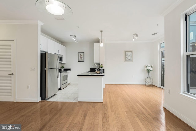 kitchen featuring appliances with stainless steel finishes, light hardwood / wood-style floors, white cabinetry, and ornamental molding