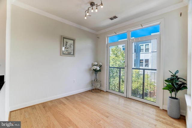 doorway to outside featuring crown molding and light hardwood / wood-style flooring