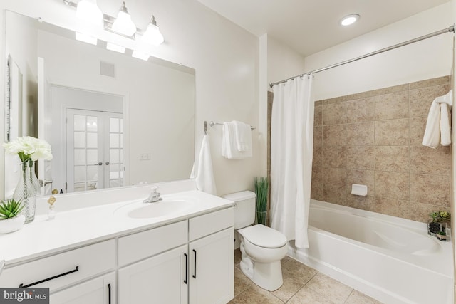 full bathroom featuring tile patterned floors, shower / bath combo with shower curtain, vanity, and toilet