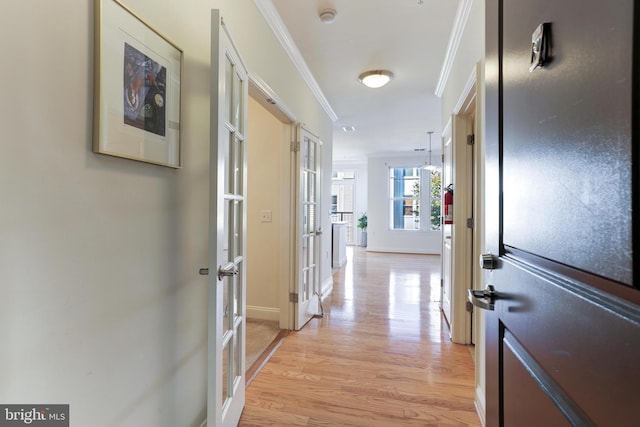 corridor with french doors, light wood-type flooring, and ornamental molding