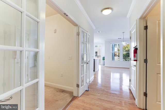 hall featuring crown molding and light hardwood / wood-style floors