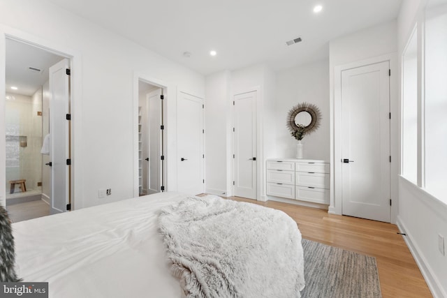 bedroom featuring ensuite bathroom and light hardwood / wood-style flooring