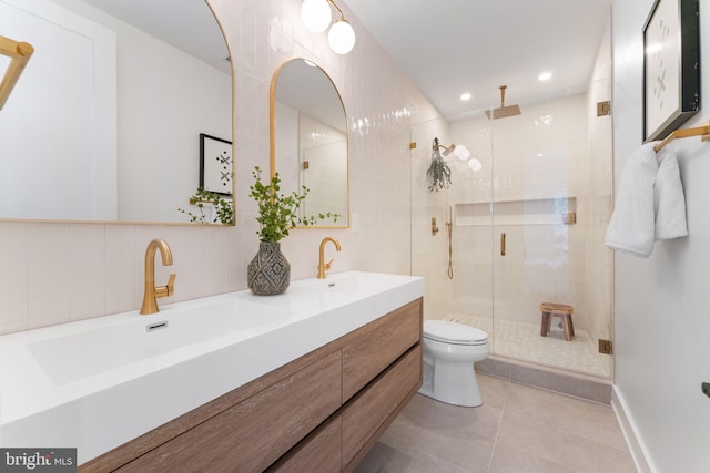 bathroom featuring tile patterned floors, vanity, toilet, and a shower with door