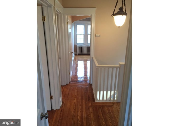 corridor featuring radiator heating unit and dark wood-type flooring