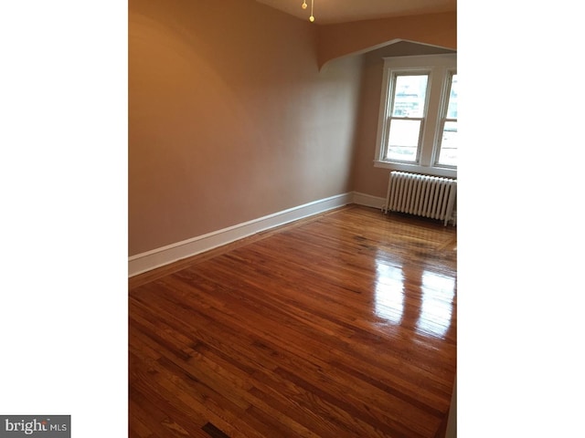 additional living space featuring radiator heating unit and hardwood / wood-style floors