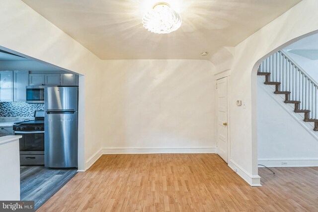 kitchen featuring light wood-type flooring, stainless steel appliances, and tasteful backsplash