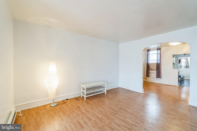 unfurnished room featuring light hardwood / wood-style floors and a baseboard heating unit