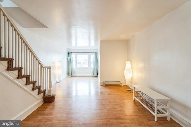 foyer with baseboard heating and hardwood / wood-style floors