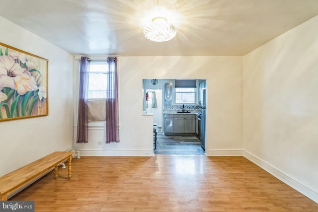 interior space with light hardwood / wood-style floors, an inviting chandelier, and sink