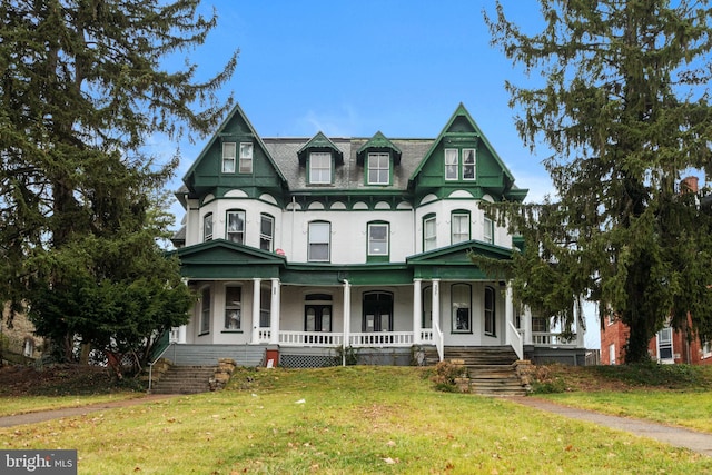 victorian house featuring a porch and a front yard