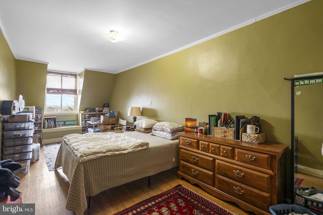 bedroom featuring ornamental molding and hardwood / wood-style flooring