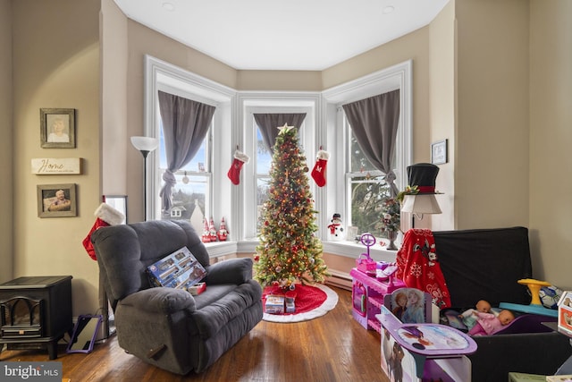 living area with hardwood / wood-style floors and a baseboard heating unit