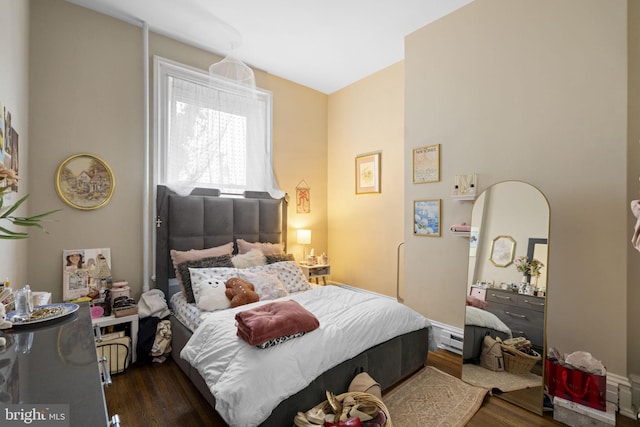 bedroom featuring baseboard heating and dark hardwood / wood-style flooring